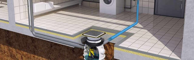 Im Bild ist eine Abwasserpumpe zu sehen, die in einem gefliesten Raum mit Waschmaschine und Rohrleitungen eingebaut ist.