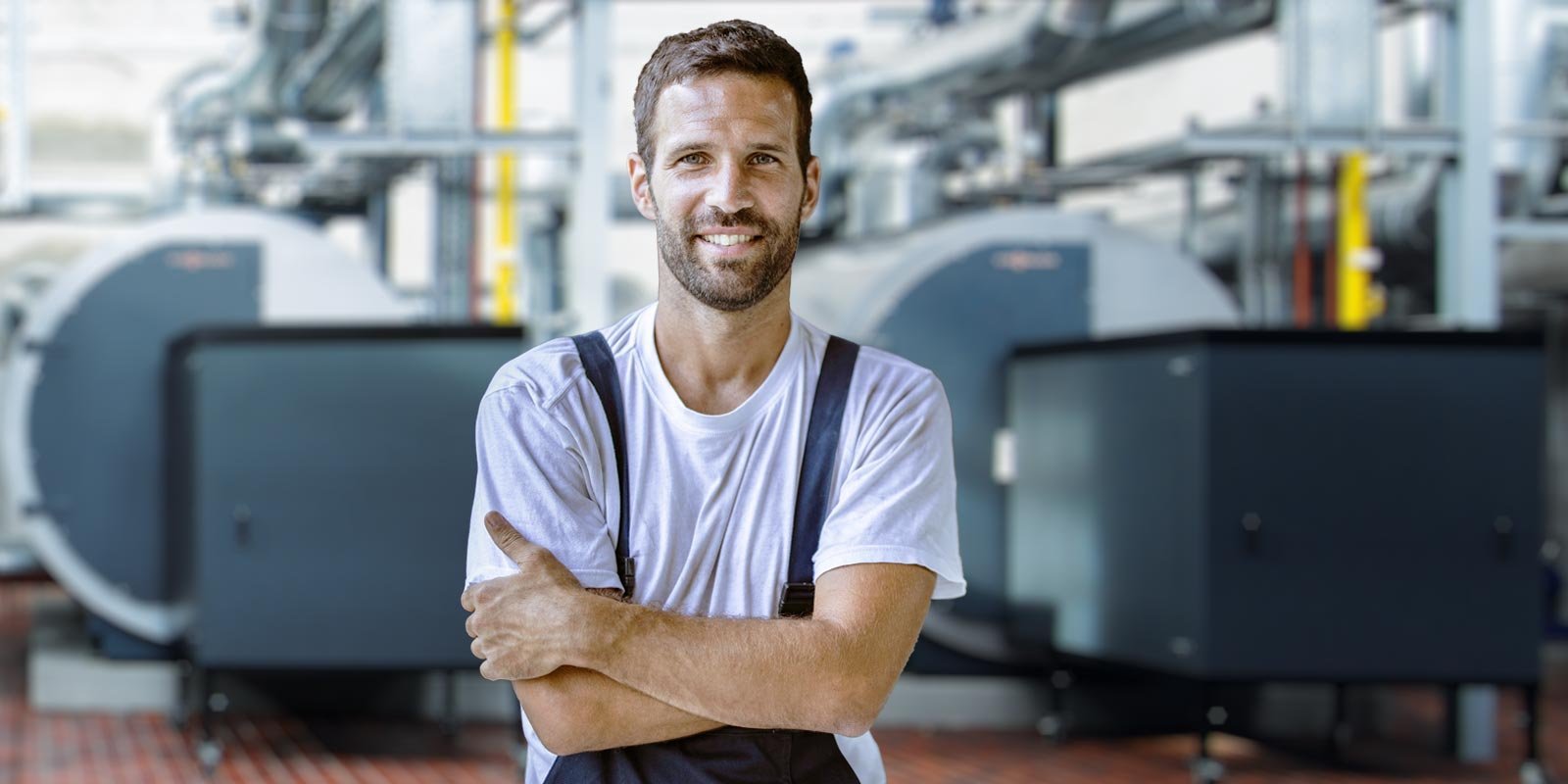 Ein Mann in Arbeitskleidung mit verschränkten Armen