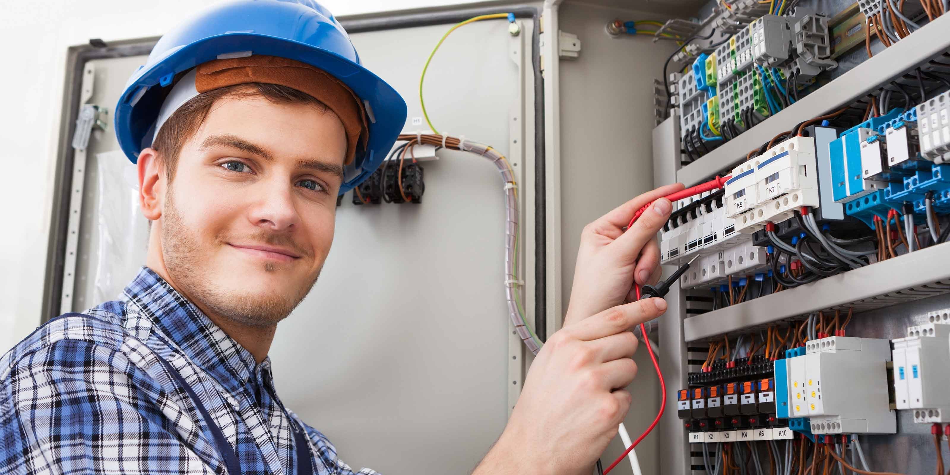 Ein junger Elektriker überprüft einen Verteilerkasten
