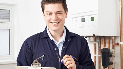 Ein junger Anlagenmechaniker mit einem Klemmbrett in der Hand 