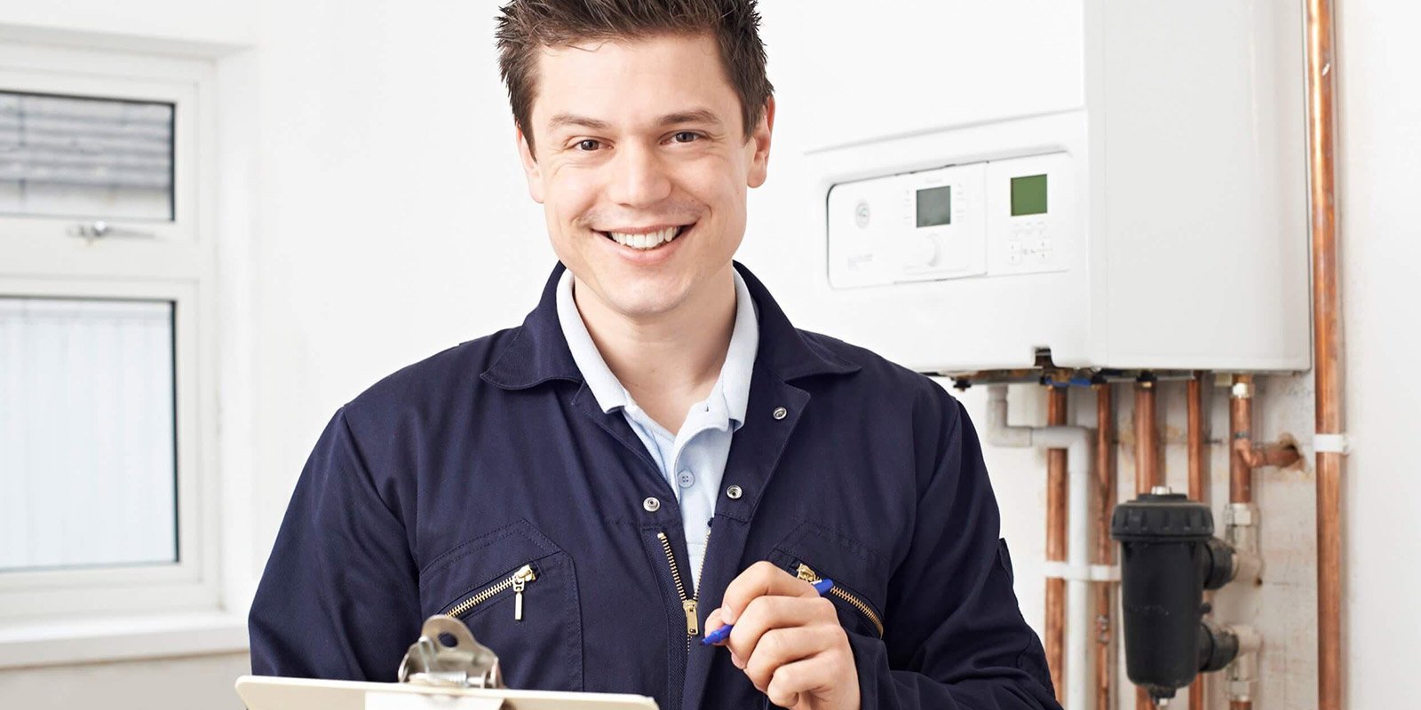 Ein junger Anlagenmechaniker mit einem Klemmbrett in der Hand